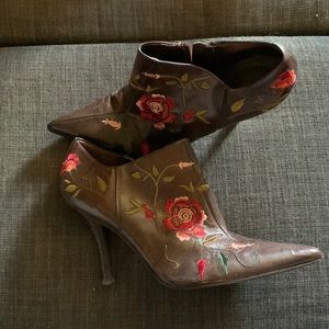 Brown ankle boot with embroidered rose pattern.
